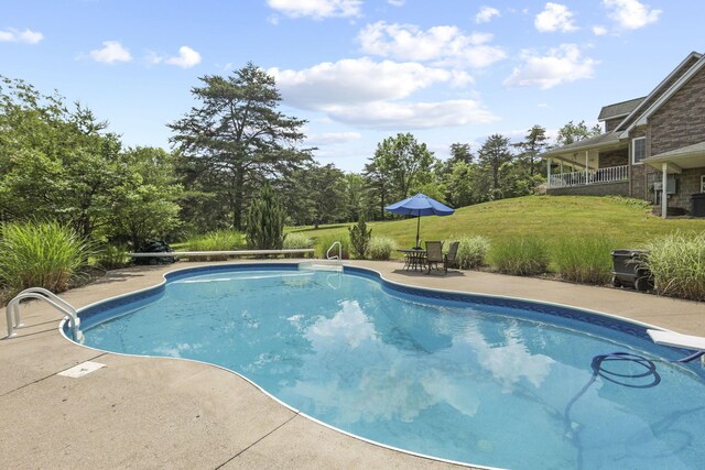 view of pool with a yard and a patio