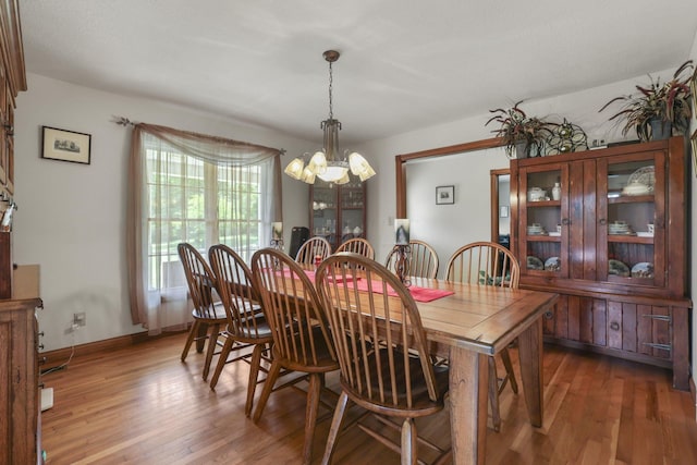 dining area with dark hardwood / wood-style floors and an inviting chandelier