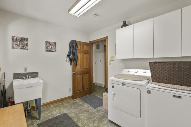 laundry area featuring washing machine and dryer and cabinets