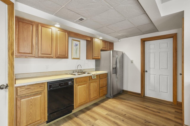 kitchen featuring dishwasher, stainless steel fridge with ice dispenser, light wood-type flooring, and sink