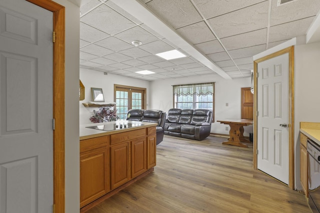 kitchen featuring a drop ceiling, light hardwood / wood-style floors, dishwasher, and black electric cooktop