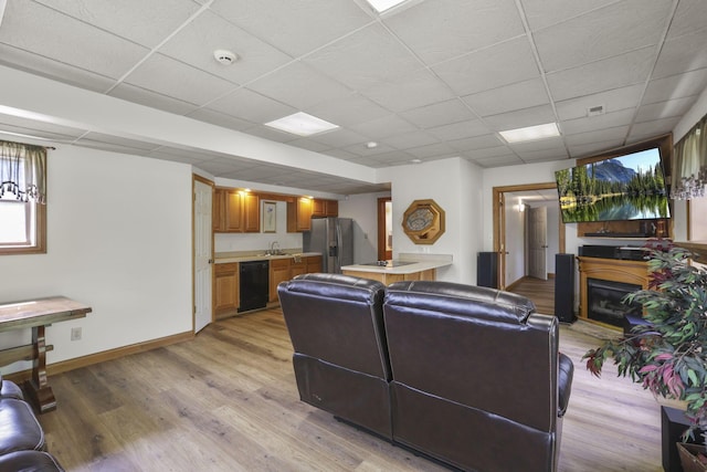 living room with light hardwood / wood-style flooring and a drop ceiling