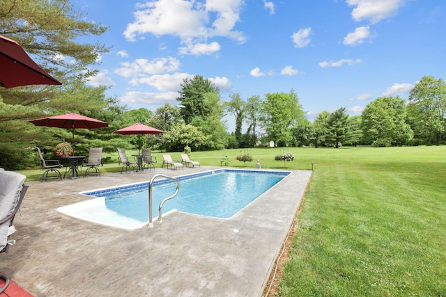 view of pool with a patio and a lawn