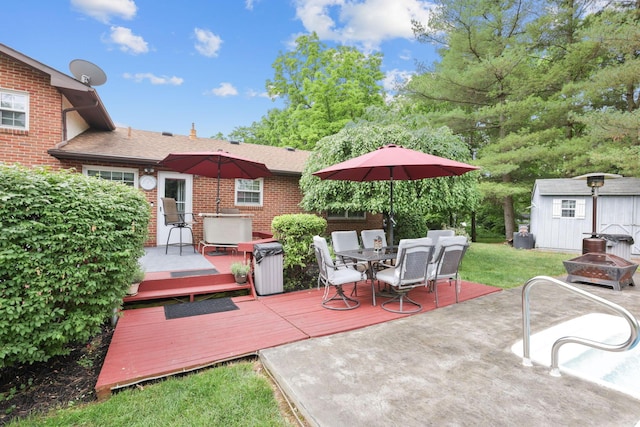 view of patio featuring a shed, a deck, and an outdoor fire pit