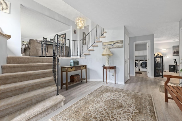 stairs with hardwood / wood-style flooring, a notable chandelier, a textured ceiling, and washing machine and clothes dryer