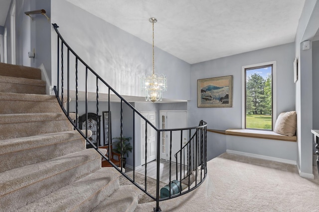 stairs with carpet floors and a notable chandelier