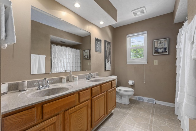 bathroom with tile patterned flooring, vanity, and toilet