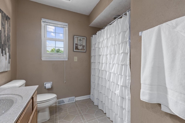 bathroom featuring tile patterned floors, vanity, and toilet