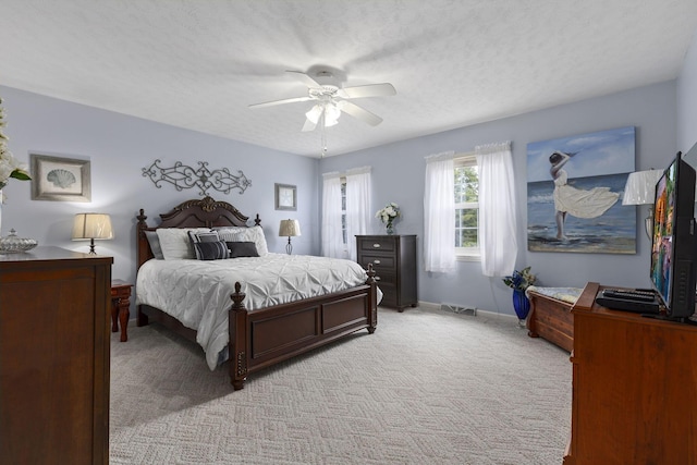 carpeted bedroom with a textured ceiling and ceiling fan