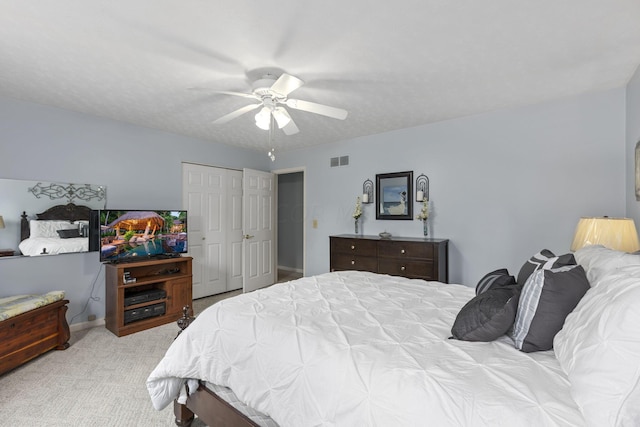 carpeted bedroom featuring a closet and ceiling fan