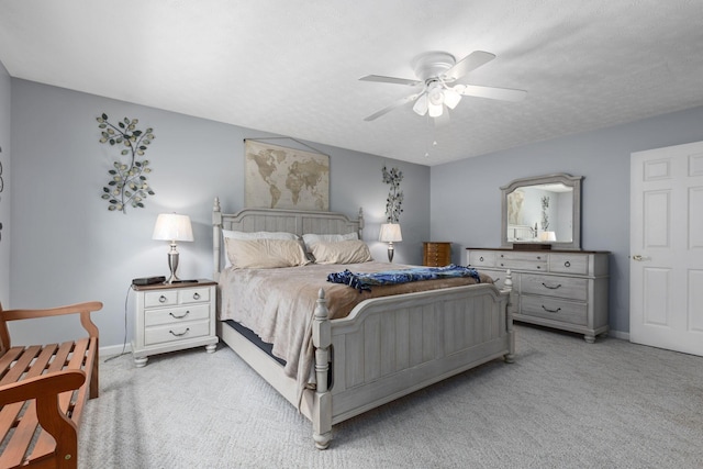 carpeted bedroom featuring a textured ceiling and ceiling fan