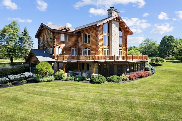 back of property with a wooden deck, a sunroom, and a yard