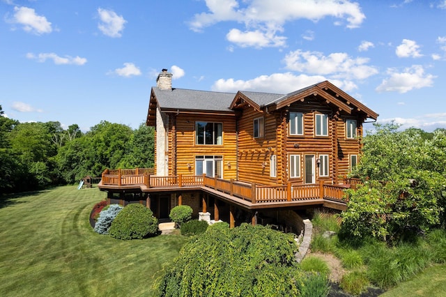 rear view of property featuring a deck and a yard