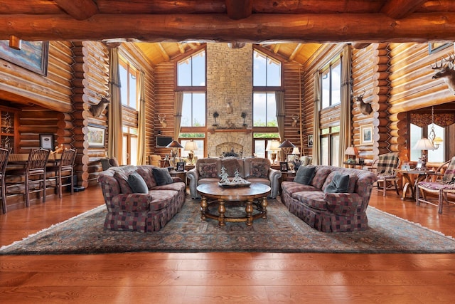 living room with hardwood / wood-style floors, beamed ceiling, high vaulted ceiling, and log walls