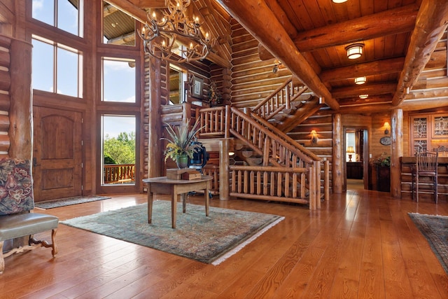 entryway with log walls, hardwood / wood-style floors, high vaulted ceiling, and wood ceiling