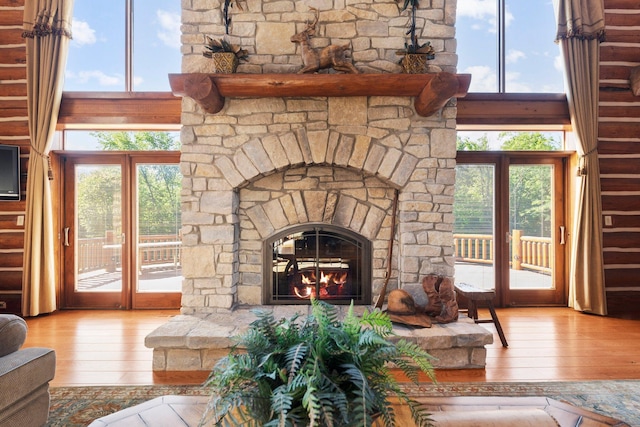 living room with french doors, light hardwood / wood-style floors, and a stone fireplace