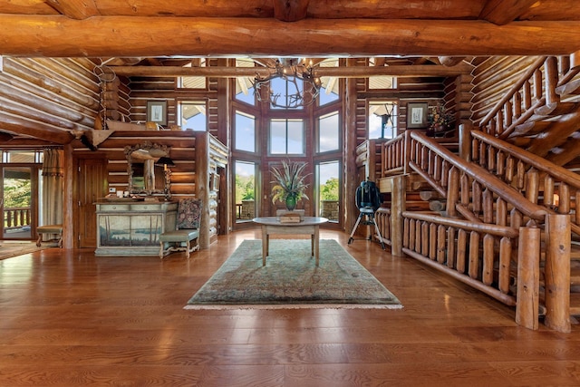 interior space featuring beamed ceiling, a notable chandelier, wood-type flooring, and log walls