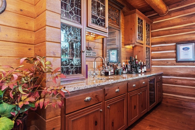 bar featuring light stone counters, dark wood-type flooring, sink, beam ceiling, and wooden ceiling