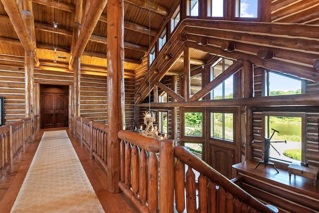 corridor featuring wooden ceiling, high vaulted ceiling, rustic walls, beam ceiling, and wood-type flooring