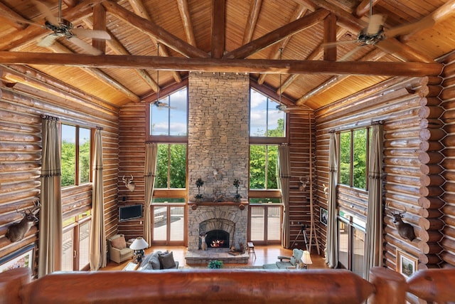 unfurnished living room with rustic walls, a wealth of natural light, and wood ceiling