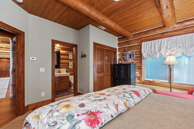 bedroom featuring beamed ceiling, ensuite bathroom, and wood ceiling