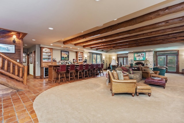 tiled living room with beamed ceiling, beverage cooler, a fireplace, and bar