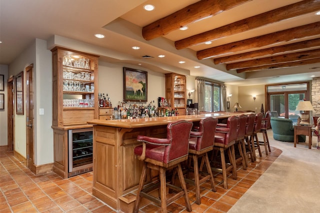 bar with a healthy amount of sunlight, beam ceiling, and beverage cooler