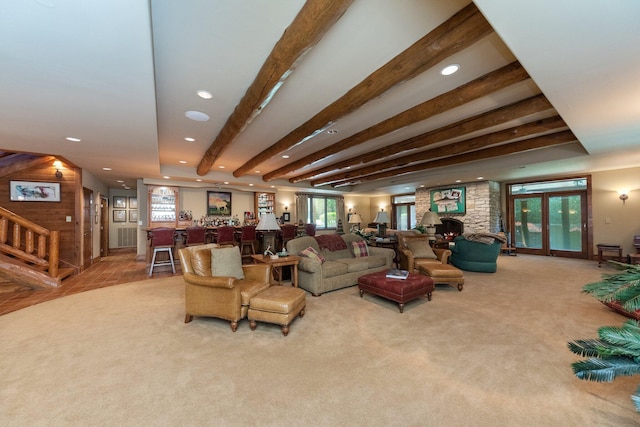 carpeted living room with bar, beamed ceiling, and a healthy amount of sunlight