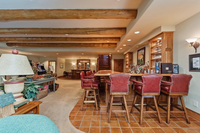 bar with tile patterned flooring and beamed ceiling