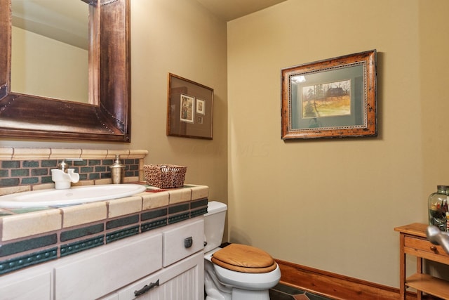 bathroom featuring tasteful backsplash, vanity, and toilet