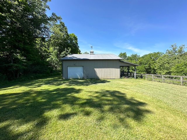 view of yard with a garage and an outbuilding