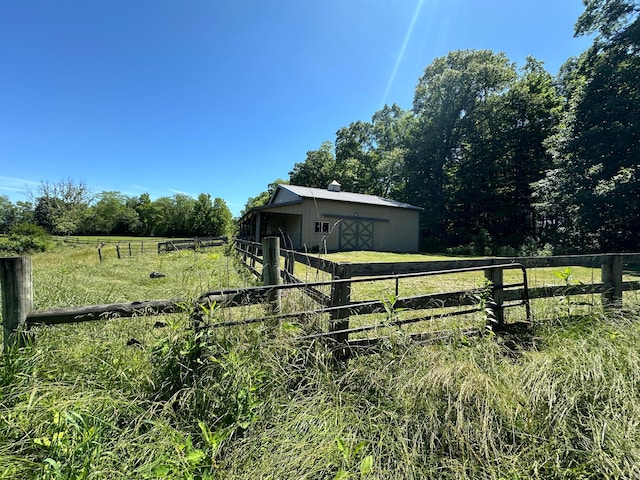 view of yard with an outbuilding and a rural view