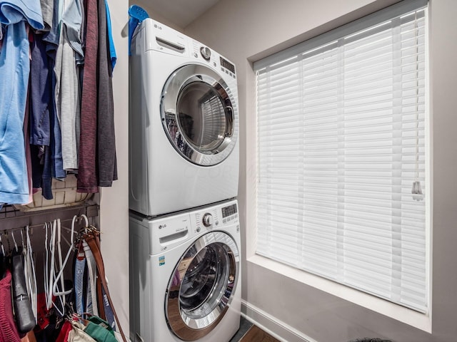 clothes washing area featuring stacked washer and clothes dryer