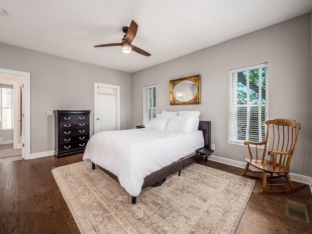 bedroom with dark hardwood / wood-style flooring and ceiling fan