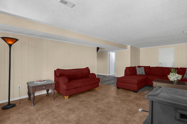 living room featuring a textured ceiling and wooden walls