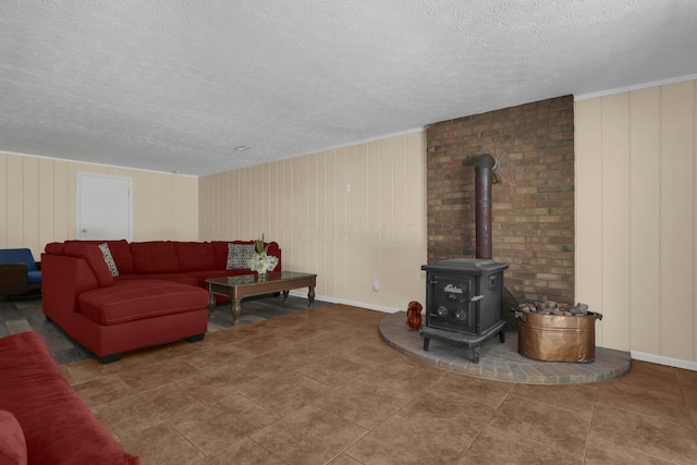 living room featuring tile patterned floors, a wood stove, and a textured ceiling