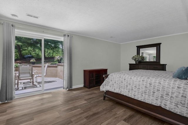 bedroom with access to exterior, ornamental molding, a textured ceiling, and hardwood / wood-style flooring