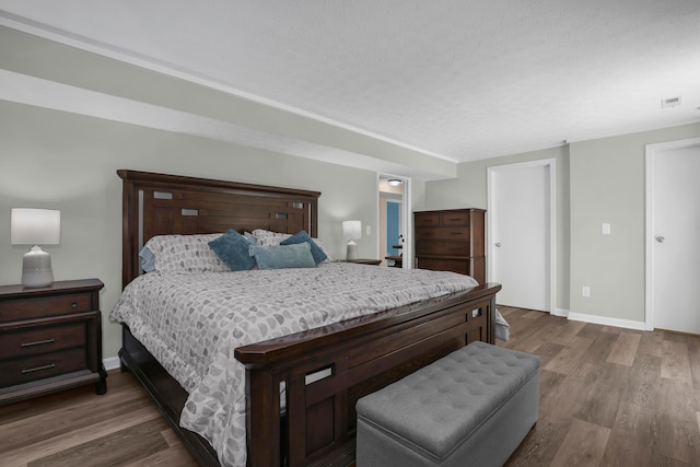 bedroom featuring a textured ceiling and dark wood-type flooring