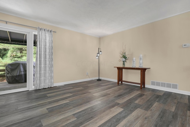 unfurnished room featuring dark hardwood / wood-style flooring and a textured ceiling