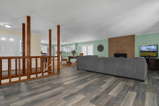 living room with a fireplace, dark hardwood / wood-style flooring, and a textured ceiling