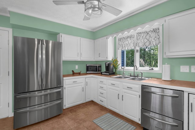 kitchen featuring white cabinetry, sink, ceiling fan, a textured ceiling, and appliances with stainless steel finishes