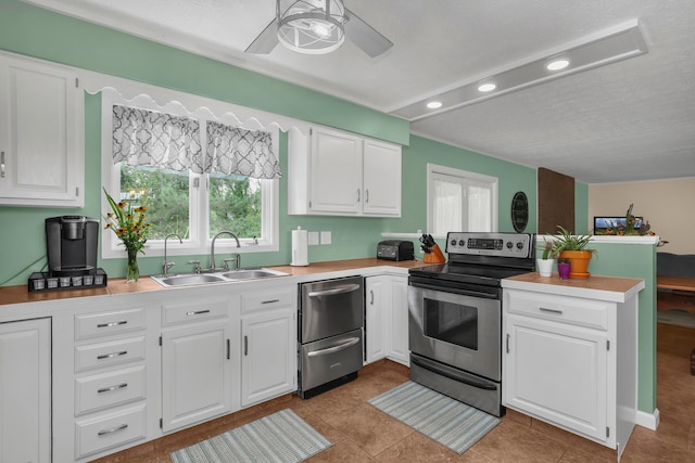 kitchen featuring electric range, white cabinetry, sink, and light tile patterned floors