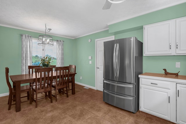 dining room with ceiling fan, crown molding, and a textured ceiling