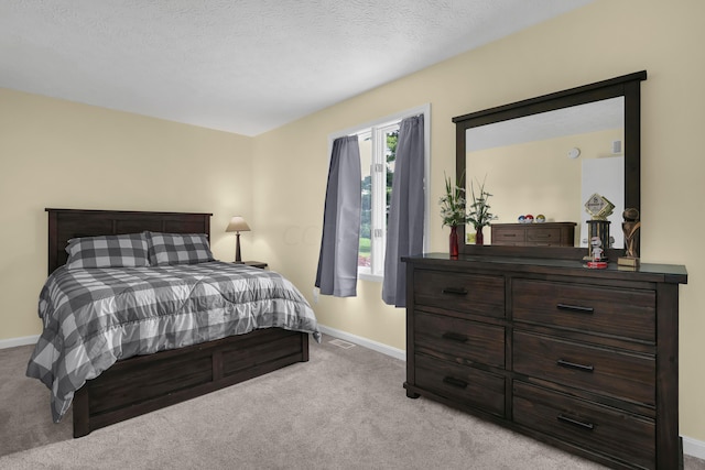 bedroom with light carpet and a textured ceiling