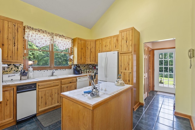 kitchen with dark tile patterned floors, high vaulted ceiling, backsplash, white appliances, and a kitchen island