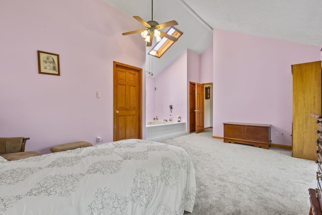 bedroom featuring high vaulted ceiling, ensuite bathroom, a skylight, ceiling fan, and carpet floors