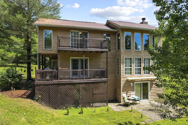 rear view of house featuring a balcony and a patio area