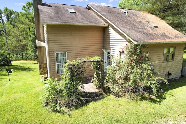 rear view of property with a lawn and central AC