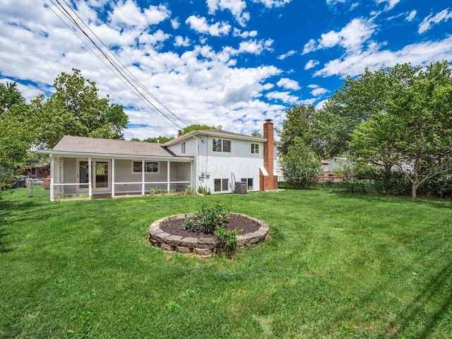 rear view of property with a sunroom, cooling unit, and a yard