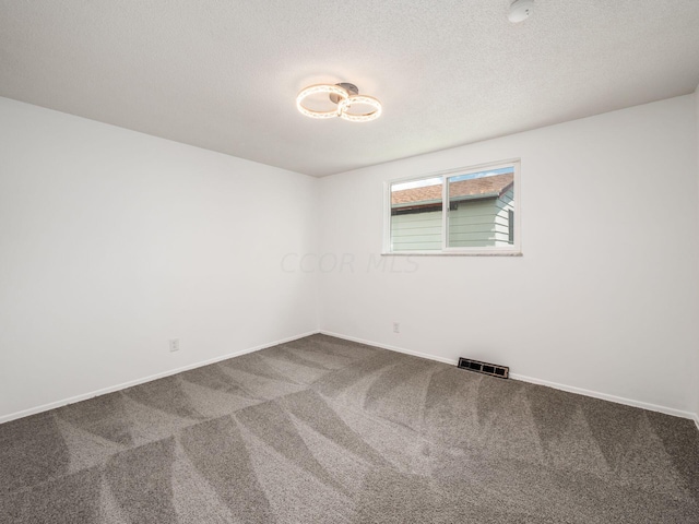 unfurnished room featuring a textured ceiling and carpet floors